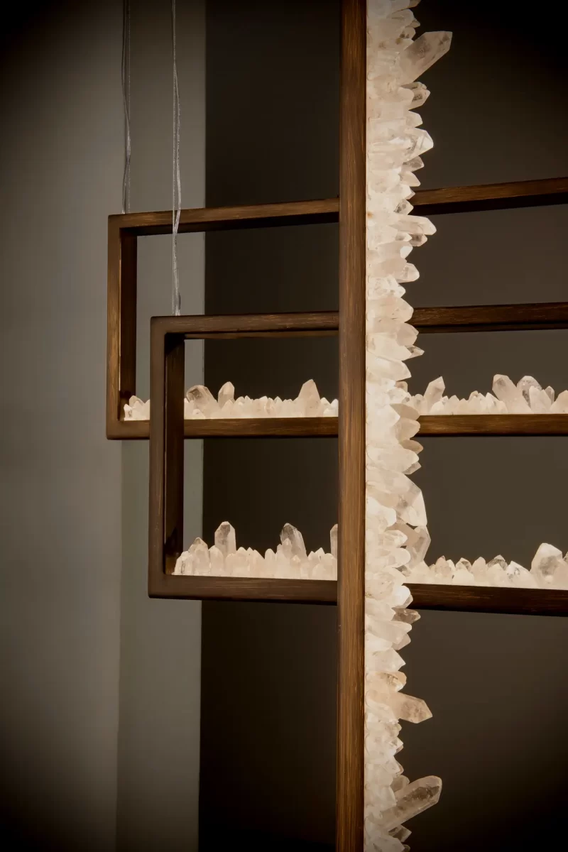 Close-up of dark silver leaf quartz pendant trios in the art gallery.