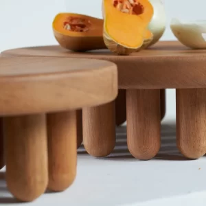 Pair of small centerpieces adorned with onions and pumpkins, in close-up on a white background.