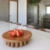 Large centerpiece with red pears on a dining table.