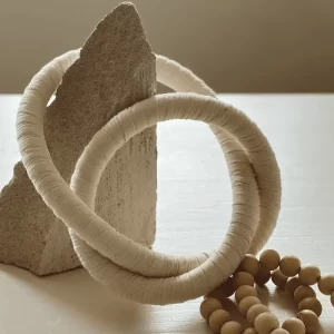 Wooden, Cotton Chain link, Wall Décor placed on a natural stone with neutral tones.