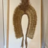 Close-up of the Freijó-colored frame of the Headdress, Indigenous Natural Fiber, Antunes, against a neutral background