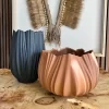 Headdress, Indigenous Natural Fiber, Antunes displayed on a wall behind black and clay-colored porcelain pieces.