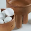 Pair of wooden bowls filled with eggs.