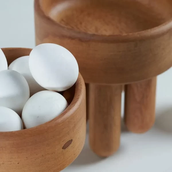 Pair of wooden bowls filled with eggs.