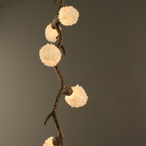 Quartz Cascade Pendant - Branches IX beautifully displayed against a neutral dark wall, highlighting natural quartz crystal lights on an arboreal ceramic frame in rustic bronze.
