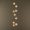 Quartz Cascade Pendant Branches IX - Arboreal Ceramic Rustic Bronze with glowing quartz crystal shades on neutral dark background.