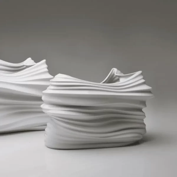 Details of the pair of matte white porcelain vases on a white background.