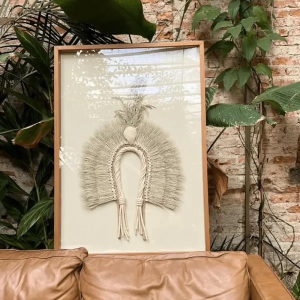 Headdress, Indigenous Natural Fiber, Modernized Sheets Hanging Above a Brown Leather Sofa on a Wall with Plants