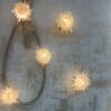 Two Artorius Natural Quartz Wall Lamp displayed on a grey wall beside other wall sconce from this collection.