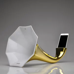 Gold Porcelain Gramophone Speaker with a smartphone inserted, demonstrating its functionality on a white background.