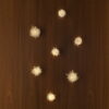 Seven Natural Quartz Wall Lamps, large and small displayed on a wooden wall.