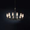 Modern circular selenite chandelier with rustic ceramic finish against a black background.