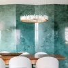 Selenite LED Chandelier San Francisco in Warm Gold Leaf Finish, Highlighting a Dining Area with Blue Granite Wall.