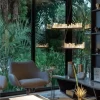 Highlighted Pair of Selenite LED Pendant Lights Lisbon in Dark Silver Leaf Finish, Featured in a TV Room with Garden View