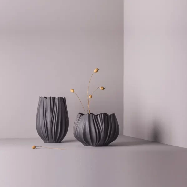 Studio composition featuring two black Snowflake Coral Fine Porcelain Vases, one small and one large.