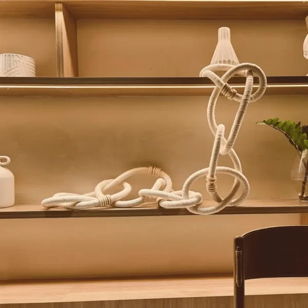 Wooden, Cotton Chain link Wall Decor exhibit on shelves in a living room.