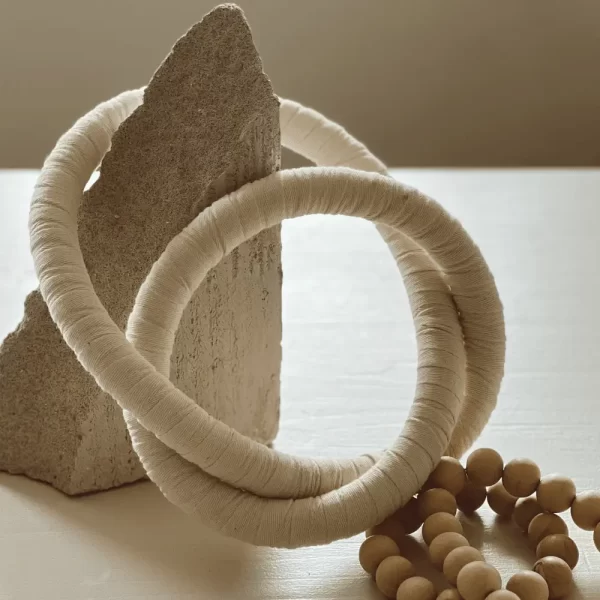 Wooden, Cotton Chain link, Wall Decor placed on a natural stone with neutral tones.